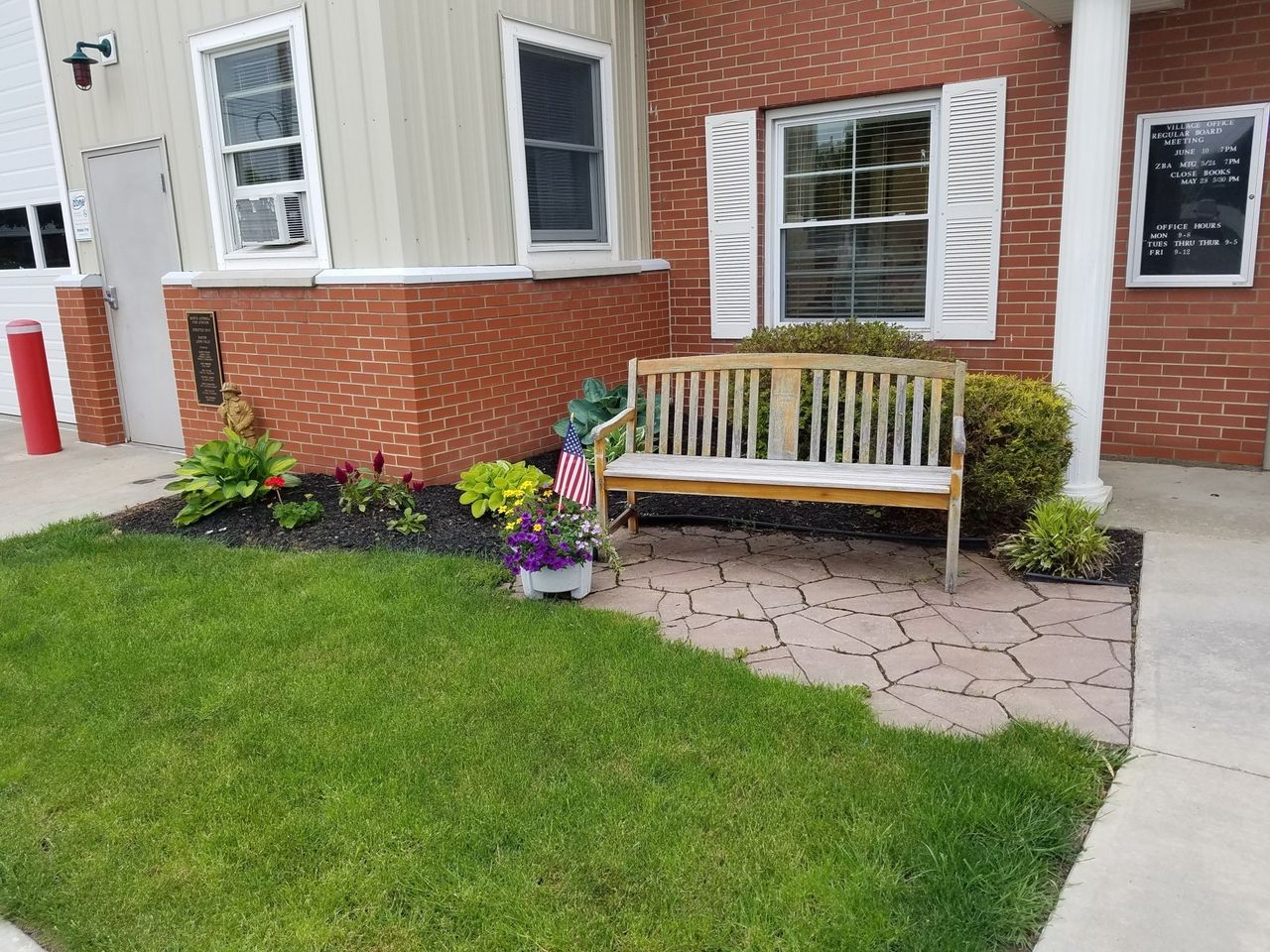 Village of North Hornell village hall location with bench next to brick building